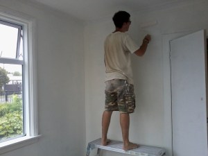 The Renovator touches up the undercoat around the new wardrobe door.
